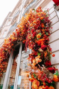 an orange and red floral wreath on the side of a building