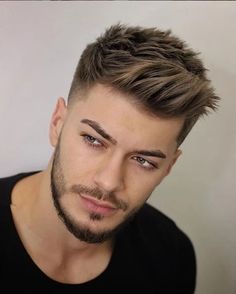 a close up of a person wearing a black shirt and a short haircut with an undercut