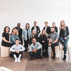 a group of people are posing for a photo in front of a white wall and floor