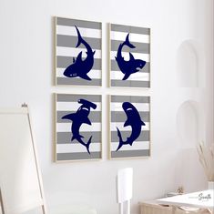 three framed pictures on the wall in a living room, with shark silhouettes above them