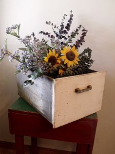 a wooden box with some flowers in it