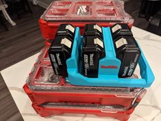 three different types of batteries in plastic cases on a table with black and white tiles