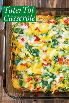 a casserole dish with spinach, cheese and other toppings on a wooden table