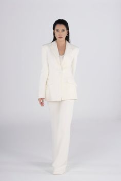 Elevate your wedding style with our Ivory Women's Single Breasted Blazer and Classic Flared Slim Fit High Waist Pant Suit. This bridal ensemble boasts a timeless design, featuring a slim fit, high waist pants, and a single-breasted blazer for a sophisticated and chic look. Whether you're walking down the aisle or celebrating at the ceremony, this elegant suit ensures you stand out with a stylish flair. Experience timeless wedding elegance with this carefully tailored and fashionable bridal outfit. Luxury Notch Lapel Wedding Pantsuit, Luxury Notch Lapel Pantsuit For Wedding, Classic Fitted Wedding Pantsuit, Luxury White Pants For Wedding, Luxury White Wedding Bottoms, Elegant Wedding Sets With Pressed Crease, Timeless Tailored Wedding Suit, Timeless Wedding Suit With Notch Lapel, Elegant Cream Pants For Evening