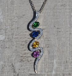 The Zuri Ladies Contemporary Multi-stone and Diamond Drop Necklace. Dangling from a 16 inch white gold chain is a 1.5 inch 14 karat white gold pendant. Add a pop of color to your outfit with this unique and modern necklace. The chain can be swapped for another length chain (shorter or longer) for an additional charge. Each piece has been hand selected and meticulously identified and graded by a Graduate Gemologist who has been awarded a degree by the Gemological Institute of America (GIA). Pleas Platinum Pendant Necklace With Gemstone, Platinum Gemstone Pendant Necklace, Platinum Silver Necklace With Gemstone, White Gold Multi-stone Cubic Zirconia Necklace, White Multi-stone Platinum Jewelry, Modern White Gold Multi-stone Jewelry, Multi-stone Diamond Pendant Gemstones, Elegant Multi-stone Oval Pendant Necklace, Modern Multi-stone Cubic Zirconia Jewelry