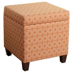 an orange ottoman with wooden legs and a geometric pattern on the top, in front of a white background