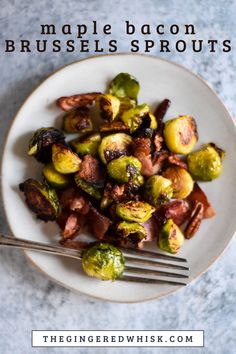 a white plate topped with brussel sprouts and bacon next to a fork