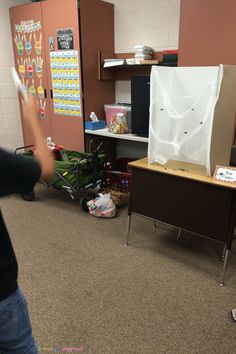 a person standing in front of a desk with a white sheet on top of it