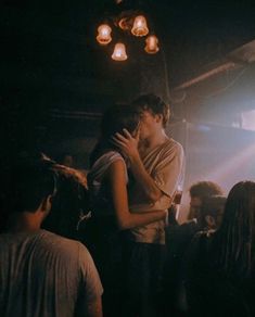 a man and woman embracing each other in front of a group of people at a concert