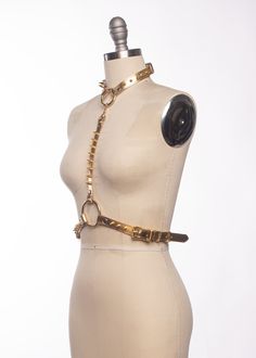 The Spina Harness is a classic harness style with a glam twist. Luxe metallic leather is lined in soft sueded pigskin and stitched. Matching spikes march up the front and around the back. Buckles at the back of neck and sides of waist for an easily adjustable fit. The choker is detachable and can be worn separately. Matching gold or silver toned hardware. Also available in gold glitter or silver glitter PVC. All pieces are MADE TO ORDER, standard sizes XS-4XL. If your measurements fall outside t Leather Strapped Harness, Fitted Leather Harness With Straps, Fitted Leather Strapped Harness, Harness Style, Fall Outside, Pig Skin, Gold Leather, Metallic Leather, Silver Glitter