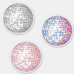 three round stickers with different colors and patterns on them, one in the shape of a disco ball