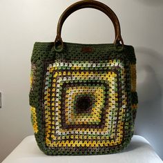 Elevate your everyday style with this handmade large crochet Granny Square bag, designed for both function and flair. Crafted with earthy tones of green, yellow, and brown, this bag features classic Granny Square motifs that evoke a vintage boho charm. The sturdy wooden handles add a touch of rustic elegance, making it easy to carry whether you're heading to the market or out for a weekend adventure. With ample interior space and practical pockets, this bag is perfect for keeping your essentials organized and accessible. Lined for durability, this bag is as functional as it is fashionable. Whether you're looking for a unique statement piece or a thoughtful gift, this Granny Square bag is a versatile addition to any wardrobe. THIS BAG IS FOR MADE TO ORDER The making process: First of all, I Green Casual Crochet Bag Hand Knitted, Green Hand-knitted Beach Bag, Green Hand Knitted Beach Bag, Casual Green Hand-knitted Crochet Bag, Casual Green Hand Knitted Crochet Bag, Casual Green Crochet Bag, Green Hand Knitted Bags For Daily Use, Green Hand-knitted Shoulder Bag For Daily Use, Green Hand Knitted Shoulder Bag For Daily Use