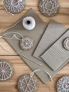 some crafting supplies are laid out on a wooden table with twine and thread