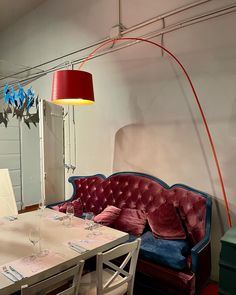 a red couch sitting next to a white table