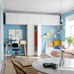 a room with blue walls and white furniture in it, including a bed that is next to a desk