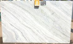 a large white marble slab sitting on top of a pile of dirt