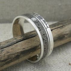 a silver ring sitting on top of a wooden stick