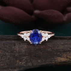 a blue sapphire and diamond ring sitting on top of a piece of wood