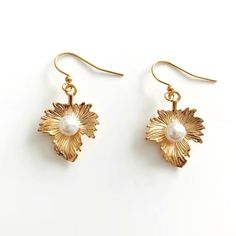 Light gold plated leaf earrings with faux pearl accent. These earrings dangle from gold plated hook ear wires. 26mm. Very pretty and elegant earrings. Elegant Leaf-shaped Metal Earrings, Elegant Leaf-shaped Gold Plated Earrings, Elegant Gold Plated Leaf-shaped Earrings, Elegant Gold Plated Leaf Earrings, Gold Pearl Dangle Flower Earrings, Guest Hairstyles, Celtic Braid, Celtic Heart, Wedding Guest Hairstyles