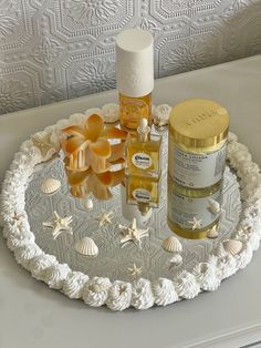 an assortment of skin care products displayed on a white tray with shells and seashells