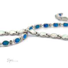 Sleek, modern, and effortlessly stunning, this lab-created opal bracelet features elegant oval-shaped stones that shimmer with a mesmerizing play of color. Available in both blue and white opal, each stone reflects a kaleidoscope of hues, reminiscent of the changing ocean or the brilliance of a clear night sky. Its simple yet striking design makes it perfect for adding a touch of understated elegance to any look, whether worn solo or stacked for a unique style. Let the opal's glow bring a little magic to your everyday. Material: .925 Sterling Silver, Rhodium Finish, Lab-Created Opal Dimensions: 7.5 inches long, 6mm x 4.5mm stones Artisan Bracelets, Locket Charms, Crystal Accessories, Opal Bracelet, Opal Earrings, Crystal Necklace Pendant, Silver Pendants, Opal Pendants, Opal Necklace