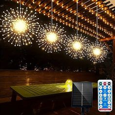 some lights that are hanging from the ceiling above a picnic table and ping pong table