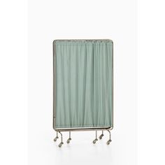 a green shower curtain sitting on top of a metal rack with wheels and handles in front of a white wall