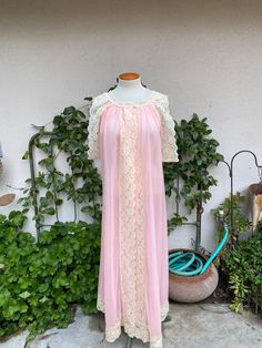 Gorgeous 1960's-1970's vintage pink robe/gown with wide cream lace trim.  Two buttons across the neckline with an open front.  Sleeveless with deep arm holes.  Double layer of fabric.  (Pics to the fabric is typical for these gowns.  I examined it carefully and didn't notice any.)  Well cared for.  Excellent vintage condition - practically mint! label:  Tosca Lingerie fabric:  nylon size:  labeled size is medium.  Based on the open style of this gown, it may fit multiple sizes.  Shown on a dress Vintage Pink Sleepwear, Vintage Pink Nightgown For Spring, Pink Vintage Sleep Dress, Pink Sleeveless Vintage Nightgown, Vintage Pink Sleep Dresses, Vintage Lace Trim Nightgown For Spring, Vintage Pink Sleeveless Nightgown, Vintage Wedding Sleepwear With Lace Trim, Pink Sheer Vintage Nightgown