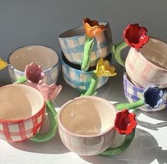 several cups with flowers in them sitting on a table