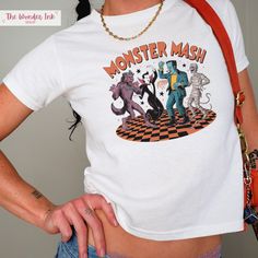 This retro Monster Mash baby tee is perfect for Halloween season! This classic baby tee will fit like a well-loved favorite from its first wear. These stylish Gildan 5000B tees feature: 💕 Made with 100% US cotton that feels soft to the touch and a great choice for any season (Heather colors - 50% cotton, 50% polyester,  Sport Grey - 90% cotton, 10% polyester) 💕 The crew neckline along with the tee's classic fit, deliver a timeless style that is perfect for daily use. 💕 All t-shirts come with Unisex Halloween T-shirt With Screen Print, Fitted Tops For Halloween Fan Merchandise, Retro Halloween T-shirt With Character Print, Halloween Pop Culture T-shirt With Funny Print, Fitted Grunge Halloween T-shirt, Unisex Halloween Graphic Print Top, Pop Culture Cotton T-shirt For Halloween, Pop Culture Halloween Cotton T-shirt, Halloween Pop Culture Cotton T-shirt