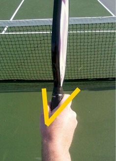 a hand holding a tennis racquet on top of a tennis court