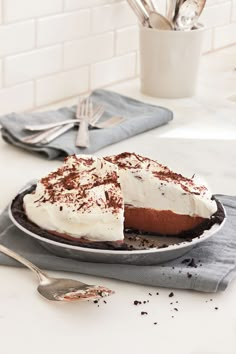 a chocolate pie with white frosting and sprinkles sits on a plate