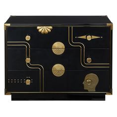 a black chest with gold accents and knobs on the front, along with an intricately designed design