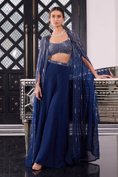 Electric blue cape with bugle beads, sequin and crystal embroidery in a striped pattern. Comes with strappy bralette and sharara.
Component: 3
Pattern: Embroidery
Type Of Work: Bugle Beads, Sequin and Crystals
Neckline: Sweetheart
Sleeve Type: Cape Sleeves
Fabric: Tussar and Organza
Color: Blue
Other Details: 
Open front cape with asymmetrical hem
Waistband embroidery
Shoulder straps
Closure: Sharara: Side zip
Occasion: Sangeet - Aza Fashions Cocktail Indian Dress, Cape Jacket Outfit Indian, Blue Mehendi Outfit, Indian Cape Outfits, Shrug Style Dresses Indian, Blue Traditional Outfit, Blue Suits Women Indian, Sharara With Cape, Sangeet Outfits For Women