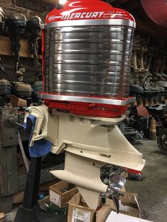 a red and white machine sitting on top of a pile of boxes in a garage