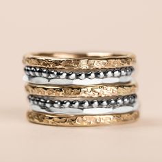 "Introducing The Demi Stack, a set of seven unique and beautiful stacking rings that are perfect for making a bold statement. Made with mixed metals in gold fill and sterling silver, each ring features a different texture, from raw silk to mirror hammered. Mix and match them to create your own unique look. Whether you're dressing up or dressing down, these rings are sure to add a touch of edge and coolness to any outfit. USA sizes 4-12. Made with high quality materials, these rings are built to Fusion Style Stackable Ring Jewelry, Fusion Style Stackable Round Rings, Fusion Style Stackable Round Jewelry, Unique Stackable Rings For Everyday, Unique Hammered Stackable Rings For Promise, Stackable Sterling Silver Fusion Rings, Unique Hammered Stackable Rings For Anniversary, Rings In Gold, Ring Bands