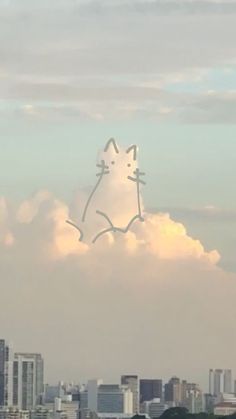 a cat drawn on the side of a cloud in front of a cityscape