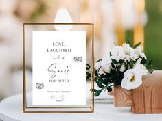 a white and gold wedding sign next to a wooden vase with flowers in it on a table