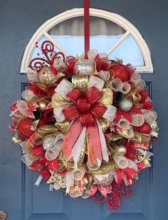 a red and white wreath hanging on the front door with christmas decorations attached to it