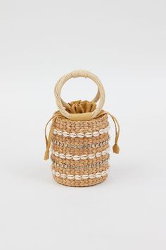 Our Leah Bag is our new favorite mini bag for spring and summer! With shell and stone embellished detail on a simple straw bag with round handles, this handheld adds style and personality to any outfit.  Material: 100% straw, 100% Cotton Lining, Shell and Stone Detail Spot Clean with Damp Cloth Chic Beach Shoulder Bag With Round Handle, Chic Shoulder Bag With Round Handle For Beach, Chic Straw Bag With Round Handle For Beach, Summer Vacation Bucket Bag With Detachable Handle, Chic Beach Bucket Bag With Round Handle, Summer Straw Bag With Detachable Handle For Beach, Elegant Straw Bag With Round Handle For Beach, Elegant Vacation Bucket Bag With Bamboo Handle, Beige Straw Bucket Bag With Round Handle