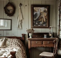 a bedroom with a bed, desk and pictures on the wall