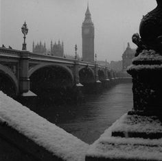 the big ben clock tower towering over the city of london covered in snow