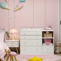 a child's bedroom with pink walls and white furniture