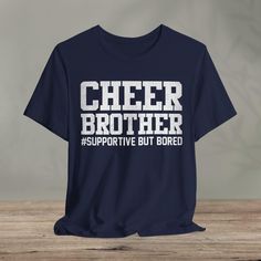 Cheer Brother Supportive But Bored - Cheerleader Brother  : - Classic unisex jersey short sleeve tee made from soft cotton.   - Quality print ensures durability and attractiveness. - Features ribbed knit collars for shaping and tapered shoulders for better fit. - Dual side seams maintain garment shape over time. - Made from 100% lightweight Airlume combed and ring-spun cotton (4.2 oz/yd²). - Ideal for layering, breathable, suitable for active and leisure wear. - Retail fit suitable for casual and semi-formal wear. - Crew neckline for classic style, easy to accessorize. - Manufactured by Bella+Canvas in the US and internationally with humane, sustainable practices. - Certified by Fair Labor Association and Platinum WRAP. - Tear-away label minimizes skin irritations. - Fabric blends include Football Cheerleader, Cheer Shirt, Semi Formal Wear, Football Cheerleaders, Funny Football, Cheer Shirts, Football Funny, Sustainable Practices, T Shirt Funny