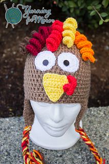 a crocheted hat with a chicken on it's head is sitting on a mannequin