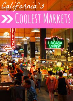 people are walking through the produce section of a grocery store with neon signs above it