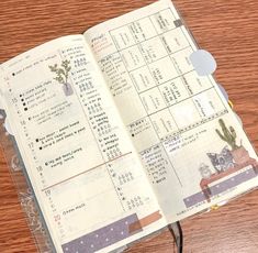 an open planner sitting on top of a wooden table