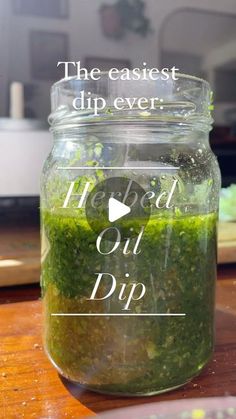 a jar filled with green liquid sitting on top of a wooden table