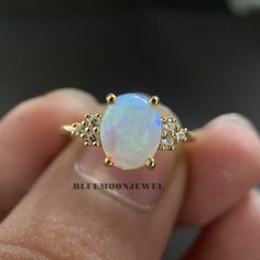 𝐌𝐚𝐢𝐧 𝐒𝐭𝐨𝐧𝐞 𝐃𝐞𝐭𝐚𝐢𝐥𝐬 *Type: Opal *Cut: Oval *Colour: FG *Clarity: VVS1 *Weight: 1.80 Ct (approx) 𝐒𝐢𝐝𝐞 𝐒𝐭𝐨𝐧𝐞 𝐃𝐞𝐭𝐚𝐢𝐥𝐬 *Type: Cubic Zirconia *Shape: Round *Colour: FG *Clarity: VVS1 *Weight: 0.20 Ct (approx) 𝐑𝐢𝐧𝐠 𝐃𝐞𝐭𝐚𝐢𝐥𝐬 *Metal Purity: Solid Gold (10k / 14k / 18k), 925 Sterling Silver *Metal Tone: White / Rose / Yellow *Stamp / Hallmarked: Yes Customization *Diamond: Natural Diamond / Moissanite / CVD -Lab Grown / Cubic Zirconia 𝐑𝐮𝐬𝐡 𝐎𝐫𝐝𝐞𝐫 *Our stan Pearl And Opal Engagement Ring, Gold Opal Ring With Halo Setting In 14k Gold, Oval Diamond Moonstone Ring In Yellow Gold, Oval Moonstone Ring With Diamonds In Yellow Gold, Gold Opal Birthstone Ring For Anniversary, Gold Opal Ring With Round Cut, Yellow Gold Opal Ring With Diamond For Anniversary, Classic Opal Ring With Round Stone For Anniversary, Classic Opal Ring For Anniversary With Round Stone