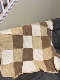 a brown and white blanket sitting on top of a couch